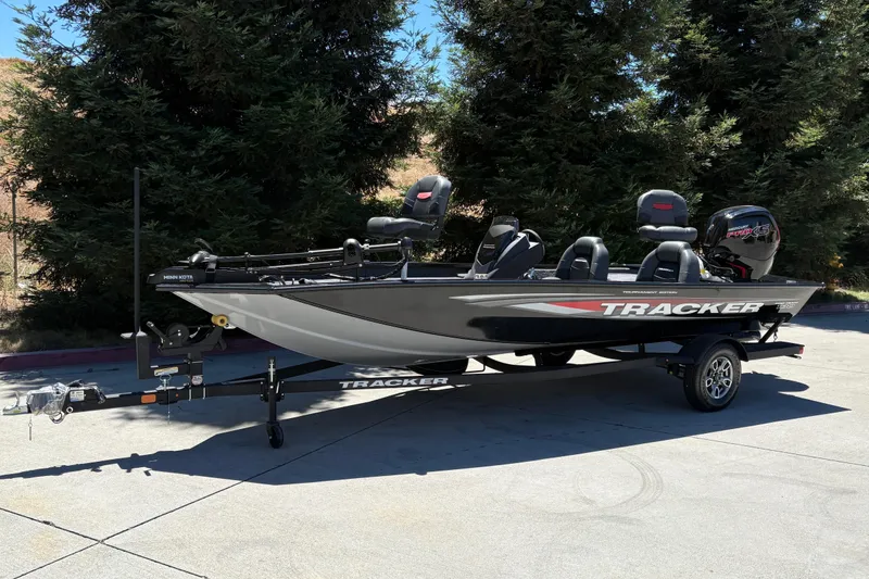 Slide: The Image of 2026 Tracker Pro Team 190 boat on trailer, parked outdoors near trees. - 3