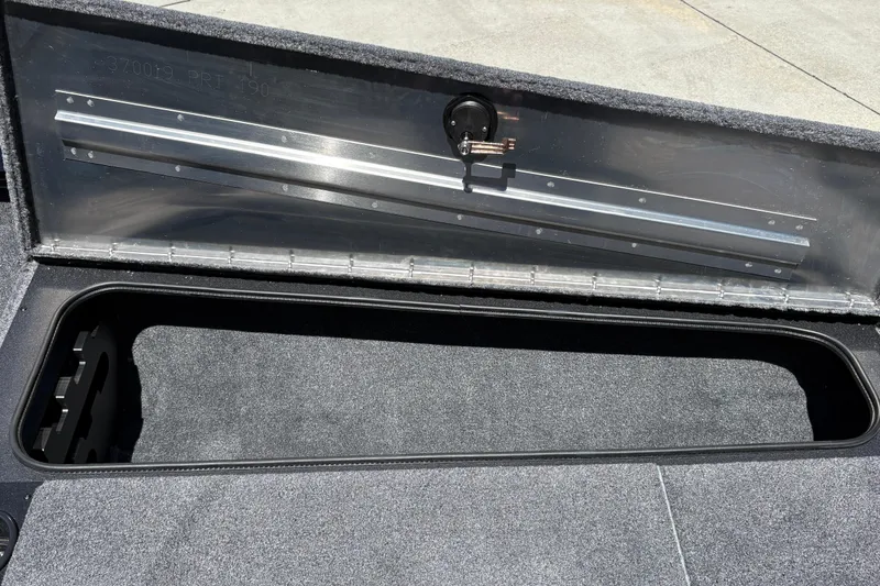 Slide: The Image of Open storage compartment in 2026 Tracker Pro Team 190 boat, featuring carpeted interior. - 34