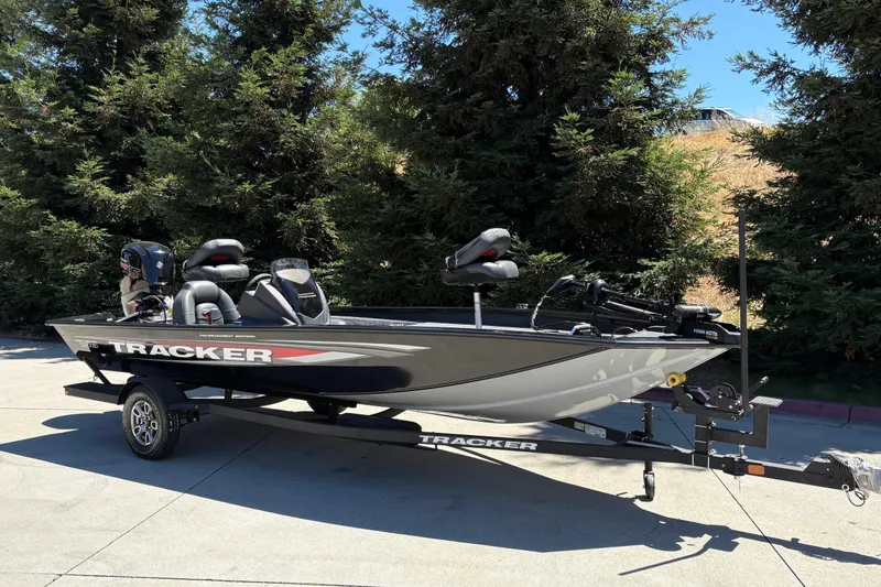 Slide: The Image of 2026 Tracker Pro Team 190 boat on trailer, parked outdoors near trees. - 7