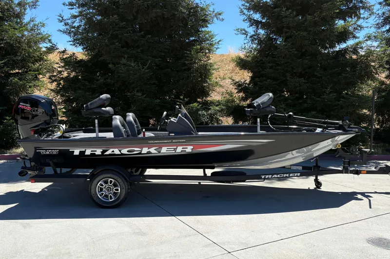 The Image of 2026 Tracker Pro Team 190 boat on trailer, parked outdoors with trees in background. - 0