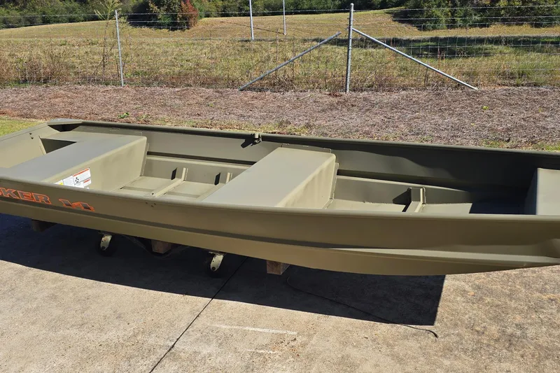 Slide: The Image of 2026 Tracker Grizzly 14 Jon boat on concrete, with grassy background. - 2