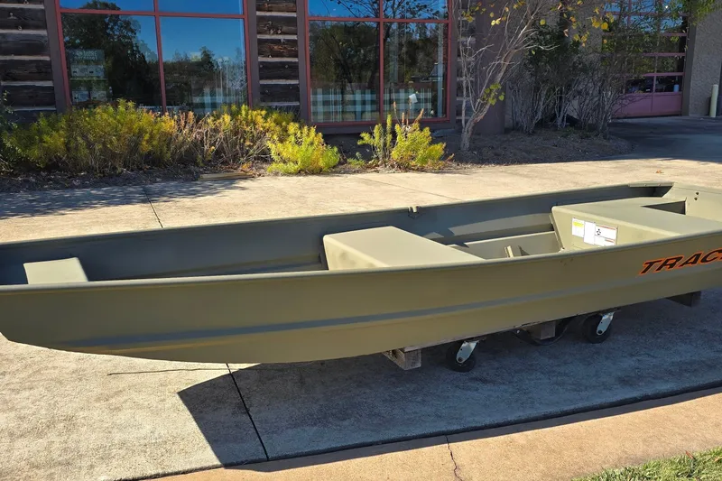 Slide: The Image of 2026 Tracker Grizzly 14 Jon boat on display outside a building. - 6