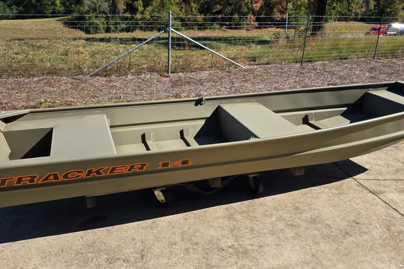 Slide: The Image of 2026 Tracker Grizzly 14 Jon boat on concrete, with grassy background. - 4
