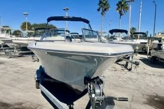 Slide: The Image of 2023 Key West 203 DFS boat on trailer, parked outdoors under clear blue sky. - 5