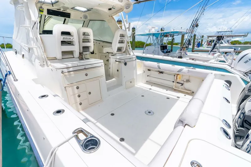 Slide: The Image of 2012 Boston Whaler 345 Conquest boat interior with seating and storage, docked in marina. - 18