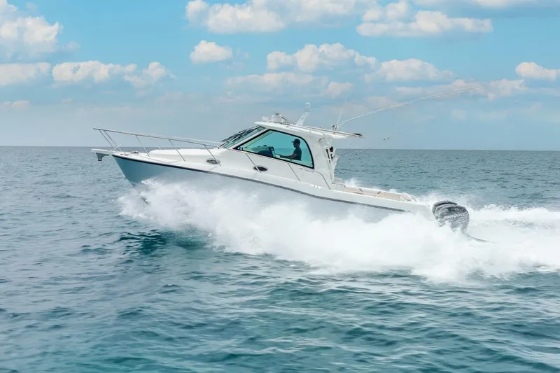 Slide: The Image of 2012 Boston Whaler 345 Conquest cruising on open water under a clear sky. - 48