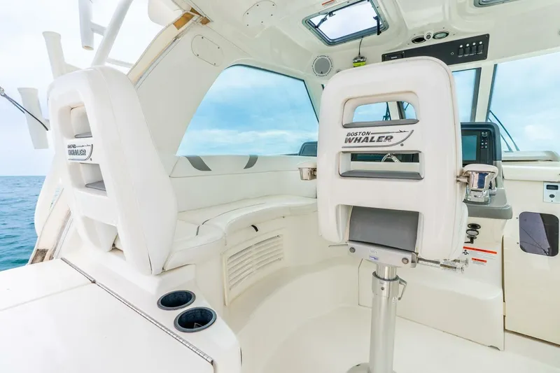 Slide: The Image of 2012 Boston Whaler 345 Conquest cockpit with white seating and ocean view. - 8