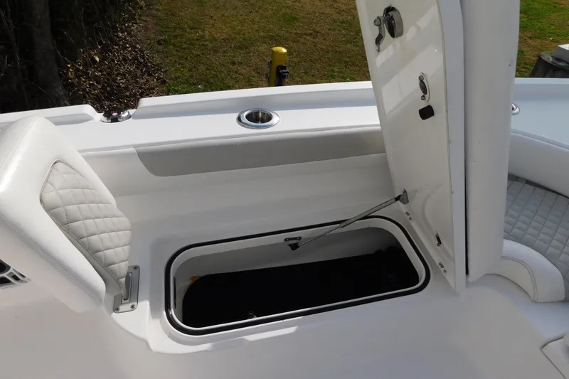 Slide: The Image of 2023 Caymas 28 HB boat storage compartment with open hatch and cushioned seating. - 23