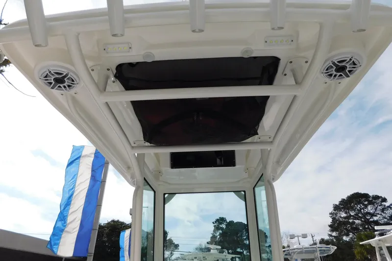 Slide: The Image of 2023 Caymas 28 HB boat roof with speakers and LED lights, under a clear sky. - 28