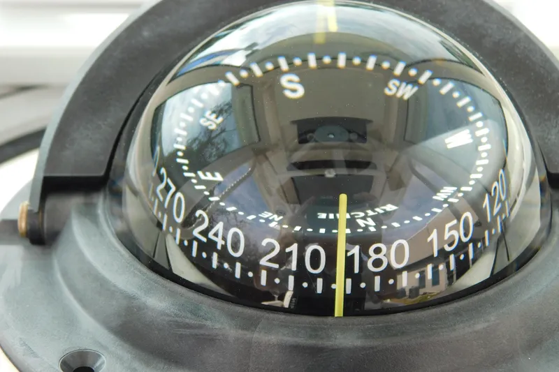 Slide: The Image of Close-up of a compass on a 2023 Caymas 28 HB boat, showing directional markings. - 38