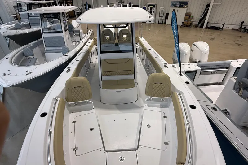 Slide: The Image of 2026 Sportsman Heritage 261 Center Console boat with beige seating in showroom. - 31