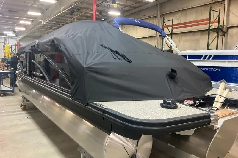 Slide: The Image of 2026 Bennington 22 MSBSF pontoon boat with cover in a warehouse setting. - 22