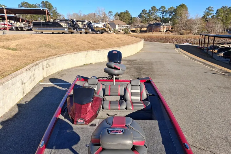 Slide: The Image of 2023 Ranger RT188 boat with red and gray seats, parked near a marina. - 6