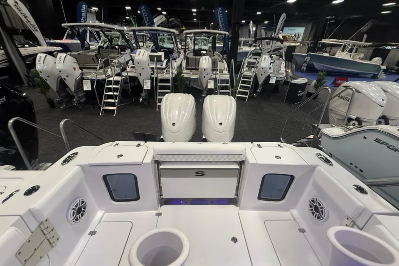 Slide: The Image of 2026 Sportsman Open 302 Center Console at a boat show, showcasing sleek design and powerful engines. - 4