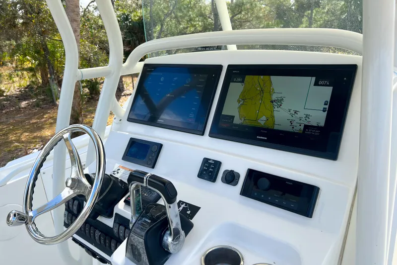 Slide: The Image of Edgewater 318CC 2011 boat dashboard with navigation screens and steering wheel. - 10
