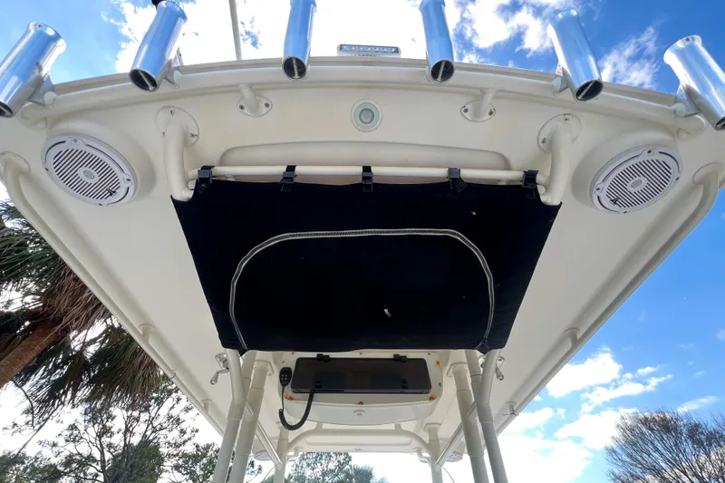 Slide: The Image of 2011 Edgewater 318CC boat canopy with speakers and rod holders under a blue sky. - 15