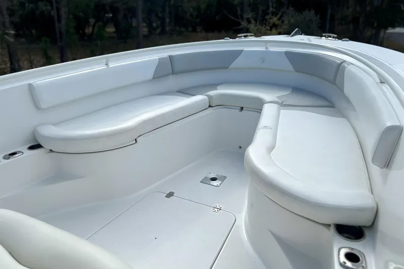 Slide: The Image of 2011 Edgewater 318CC boat interior with white cushioned seating and cup holders. - 21