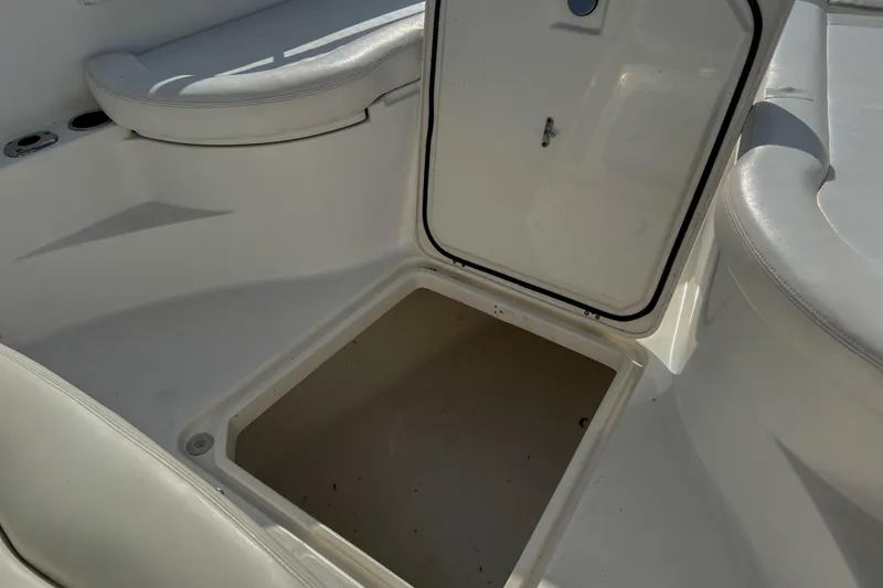 Slide: The Image of Open storage compartment on 2011 Edgewater 318CC boat, featuring white cushioned seating. - 22