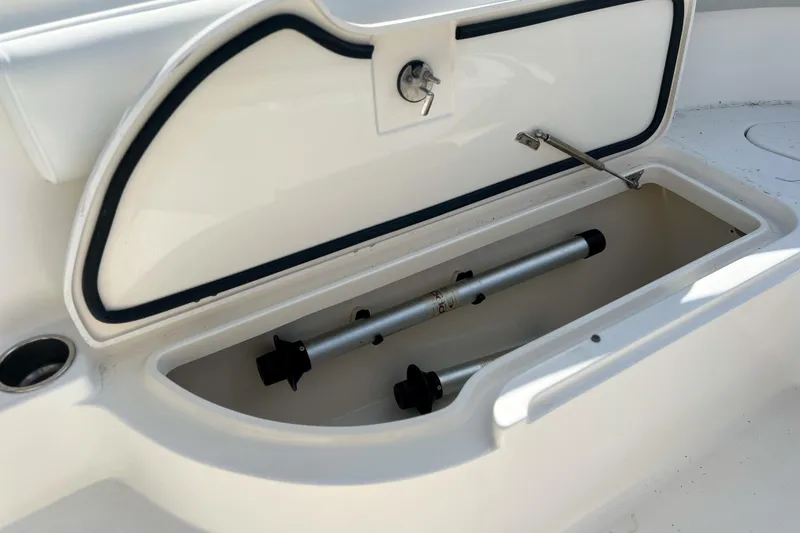 Slide: The Image of Open storage compartment on a 2011 Edgewater 318CC boat, featuring metal rods inside. - 23