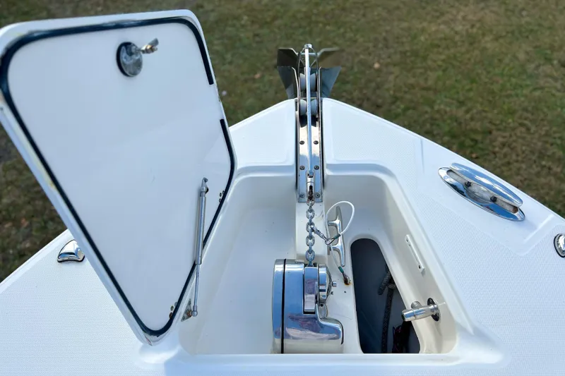 Slide: The Image of Open anchor compartment on 2011 Edgewater 318CC boat, showcasing chain and winch system. - 26