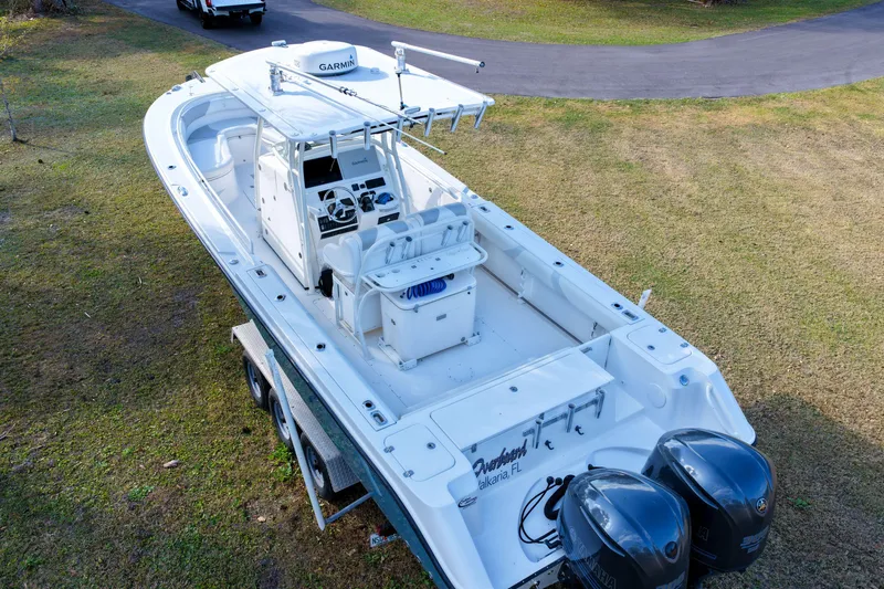 Slide: The Image of 2011 Edgewater 318CC boat with dual Yamaha engines on a trailer, parked on grass. - 3