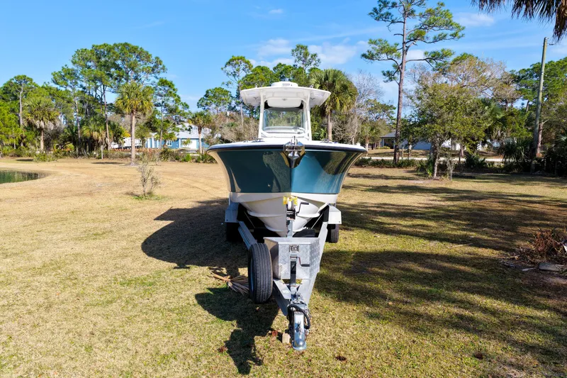 Slide: The Image of 2011 Edgewater 318CC boat on trailer in grassy area with trees. - 32