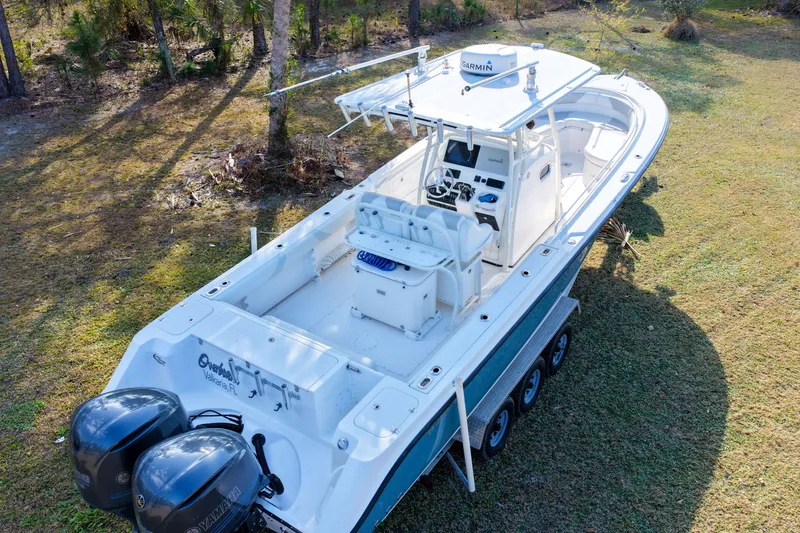 Slide: The Image of 2011 Edgewater 318CC boat with dual Yamaha engines on grassy terrain. - 35