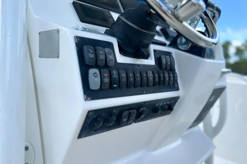 Slide: The Image of Control panel of a 2011 Edgewater 318CC boat with steering wheel and switches. - 8