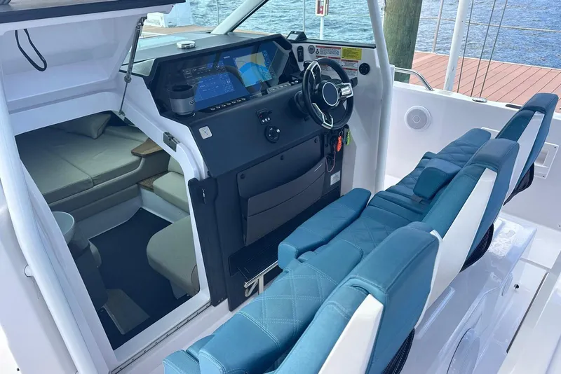 Slide: The Image of 2021 Axopar 37 Sun-Top cockpit with modern dashboard and blue seating. - 10