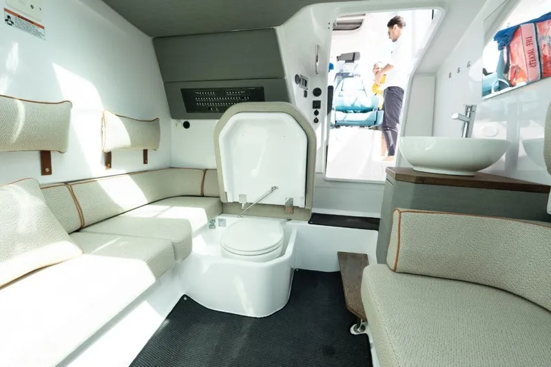 Slide: The Image of Interior of 2021 Axopar 37 Sun-Top boat with seating and compact bathroom. - 12