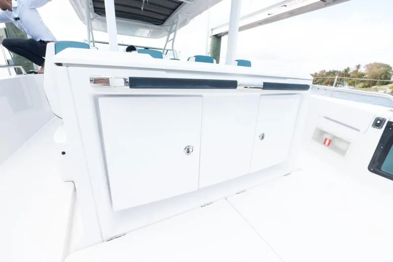 Slide: The Image of 2021 Axopar 37 Sun-Top boat interior with sleek white cabinetry and modern design. - 15