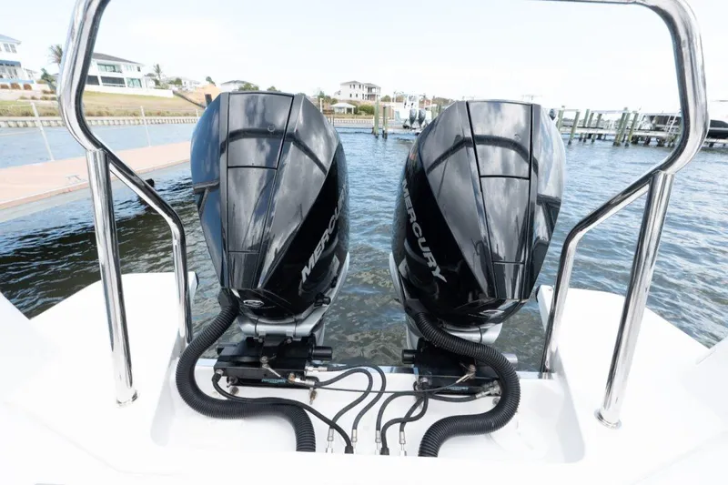 Slide: The Image of Twin Mercury outboard engines on a 2021 Axopar 37 Sun-Top boat, docked by the water. - 17