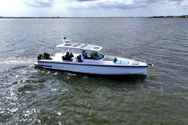 Slide: The Image of 2022 Axopar 37 Sun-Top boat cruising on open water under cloudy skies. - 2