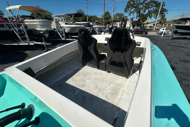 Slide: The Image of 2022 Lightning 18 boat interior with two black seats, parked among other boats. - 10