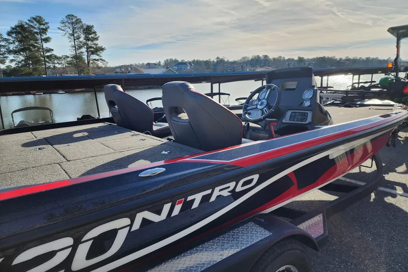 Slide: The Image of 2021 Nitro Z20 boat with sleek design, docked by a scenic lake. - 5