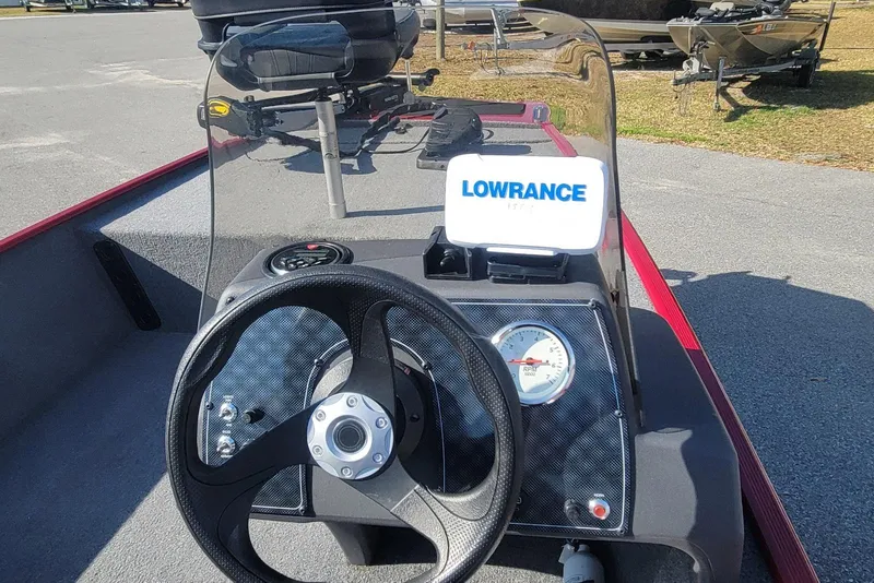 Slide: The Image of 2024 Tracker Bass Tracker Classic XL dashboard with steering wheel and Lowrance display. - 15