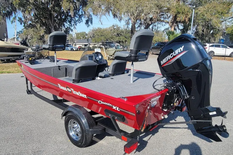 Slide: The Image of 2024 Tracker Bass Tracker Classic XL boat with Mercury engine, parked outdoors. - 6