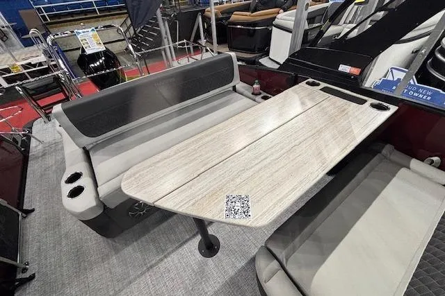 Slide: The Image of 2026 Harris Sunliner 230 boat interior with spacious seating and wooden table. - 11