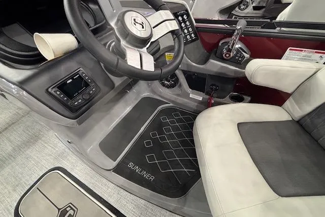 Slide: The Image of 2026 Harris Sunliner 230 boat interior with steering wheel, controls, and seating. - 20