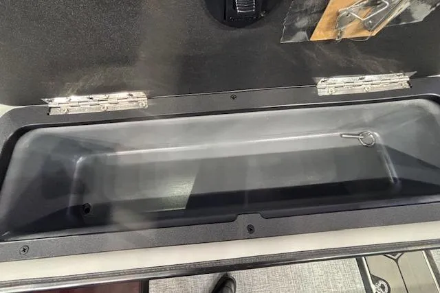 Slide: The Image of Storage compartment of 2026 Harris Sunliner 230 boat, featuring secure latch and hinges. - 27