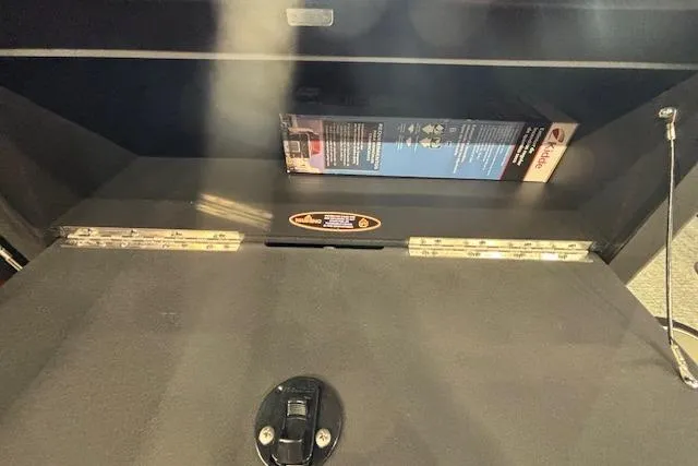 Slide: The Image of Storage compartment of 2026 Harris Sunliner 230 boat, featuring a secure latch and interior contents. - 28