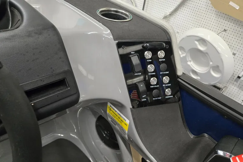 Slide: The Image of Control panel of 2026 Harris Sunliner 230 boat with various switches and cup holder. - 18