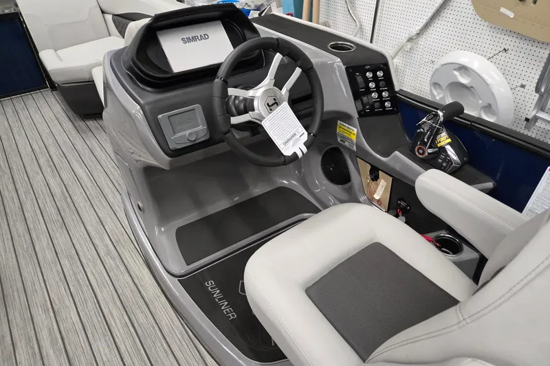 Slide: The Image of 2026 Harris Sunliner 230 boat dashboard with steering wheel and control panel. - 31