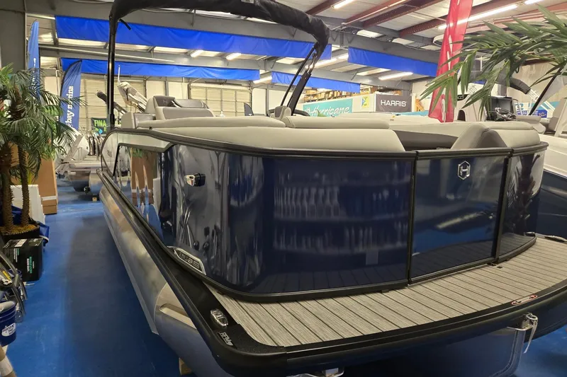 Slide: The Image of 2026 Harris Sunliner 230 pontoon boat displayed indoors with sleek design and comfortable seating. - 7