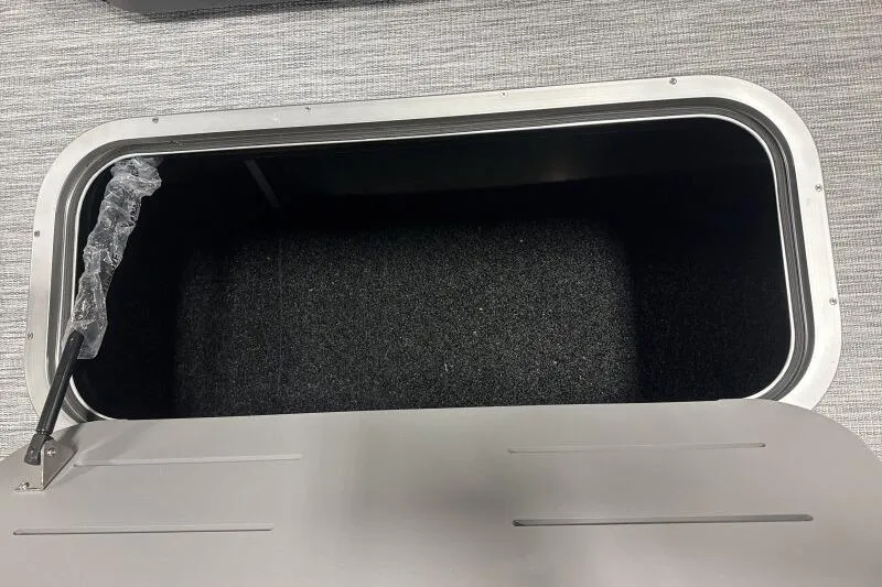 Slide: The Image of Storage compartment of 2026 Bennington 22 SSBSF boat, open with black interior. - 16