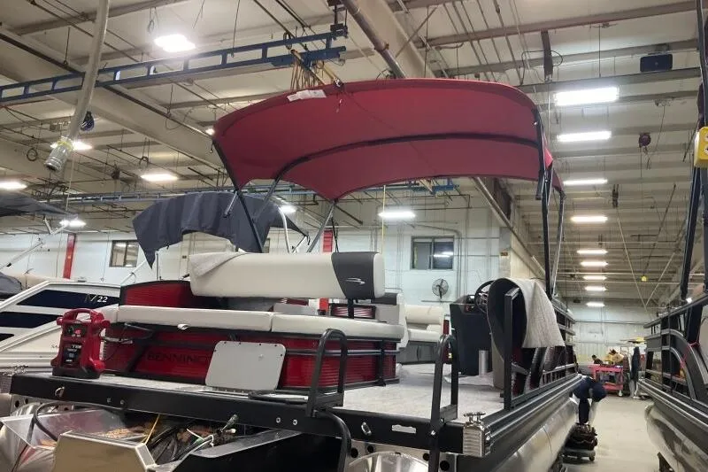 Slide: The Image of 2026 Bennington 22 SSBSF pontoon boat in a factory setting with red canopy. - 18