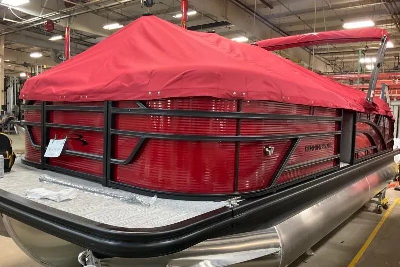 Slide: The Image of 2026 Bennington 22 SSBSF pontoon boat with red cover in a factory setting. - 20
