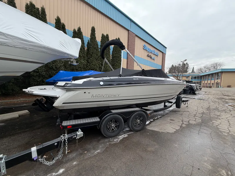 Slide: The Image of 2019 Monterey 224FS boat on trailer in front of building. - 2