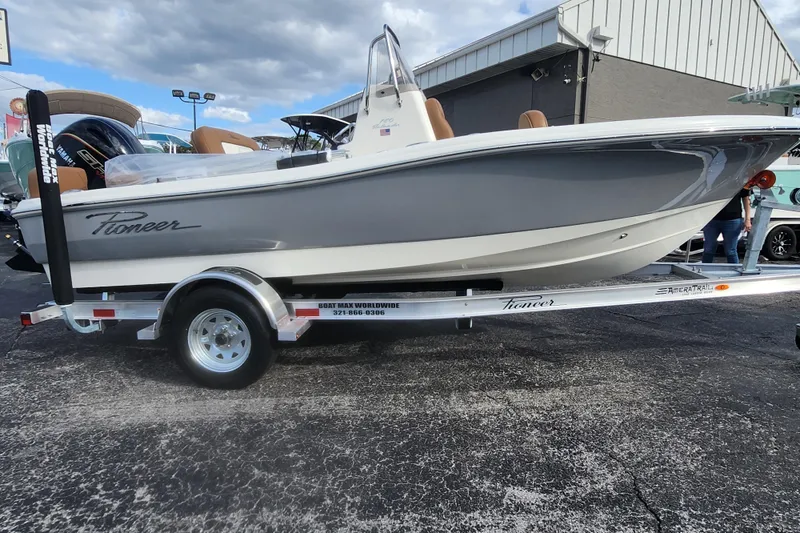 Slide: The Image of 2026 Pioneer 180 Islander boat on trailer, displayed outdoors under cloudy sky. - 12