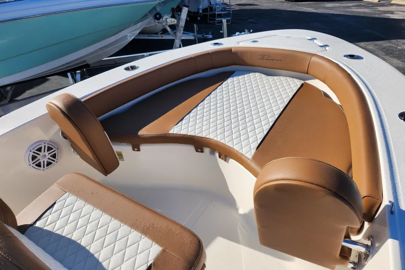 Slide: The Image of 2026 Pioneer 180 Islander boat interior with brown and white cushioned seating. - 9